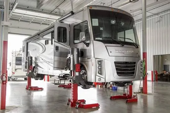 Motorhome raised on lifts in the service bay