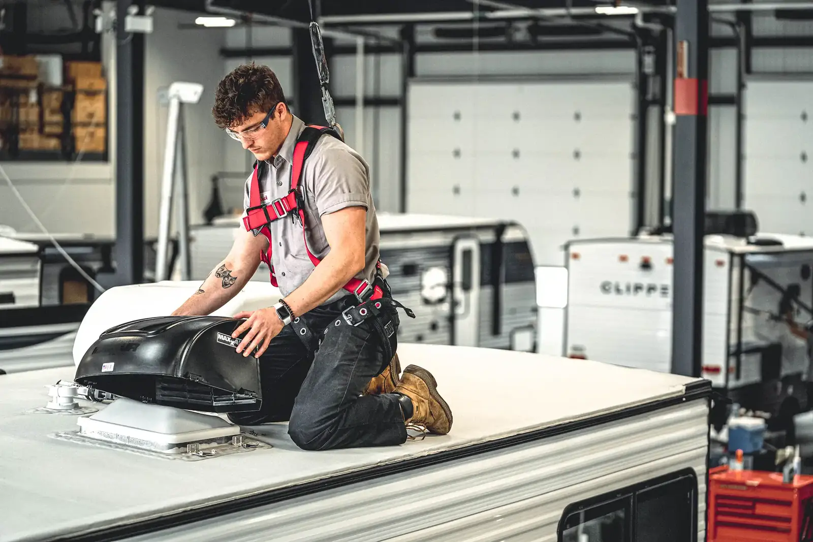 Technician fitting an air conditioner on an RV roof